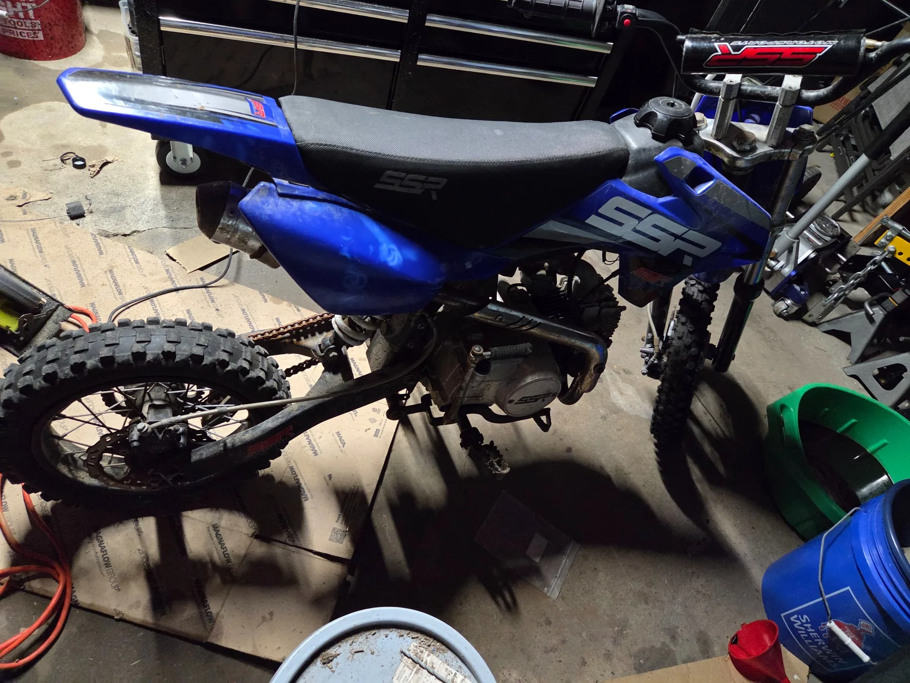 Opposite-side view showing engine, chain, controls, and chassis.
